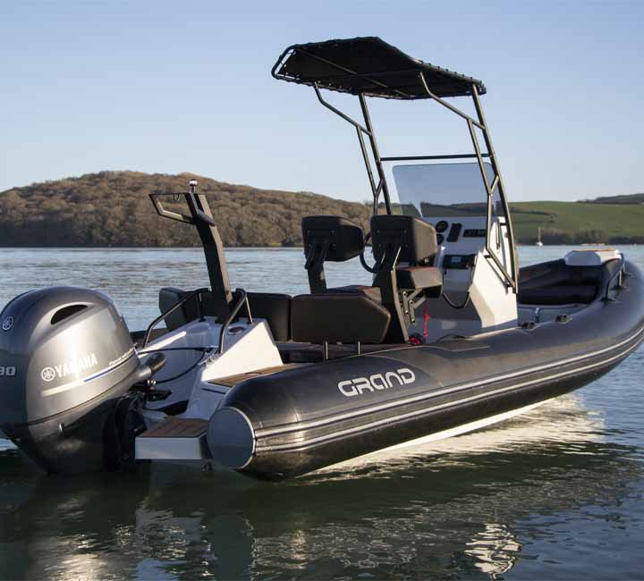 A Grand D600 sat on the water with a t-top bimini, ski pole and Yamaha engine on the back