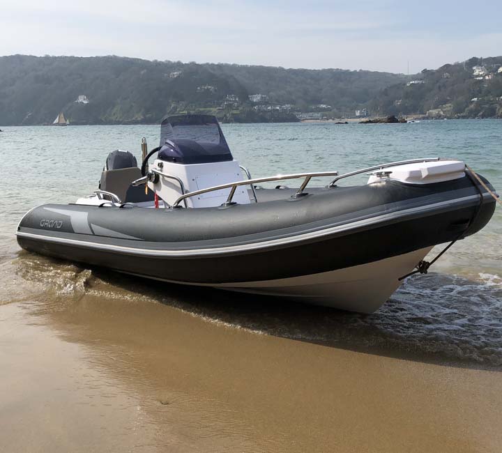 A dark grey Grand G420 beached on the sand