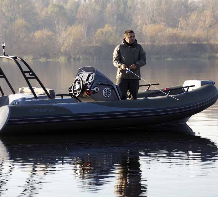 A Grand G500 sat on the water with its passenger fishing off the side