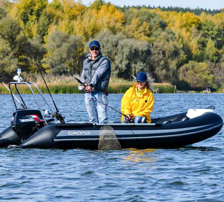 Two passengers fishing off the side of a black Grand S370