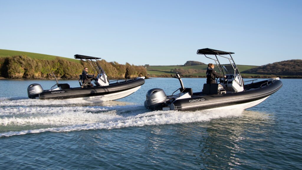 Two Grand D600s with black tubes on the water, serving as Diving Boats