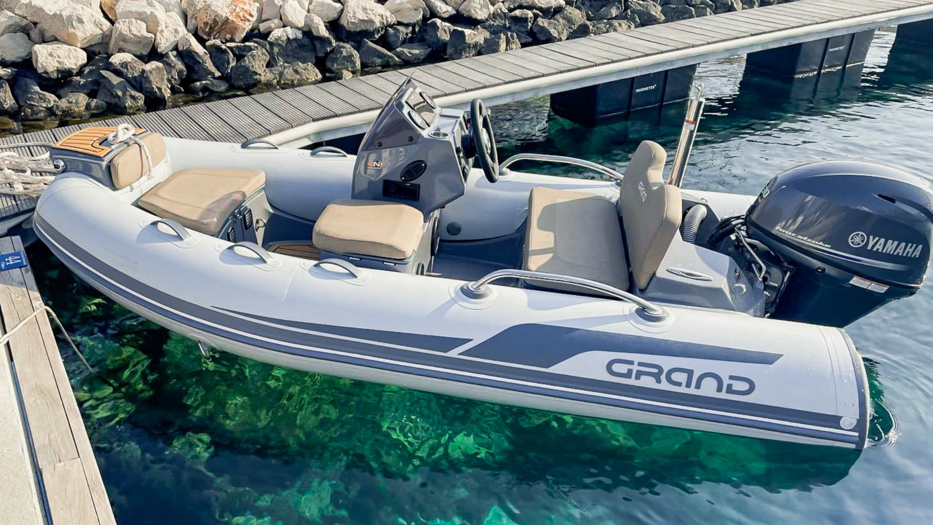 The Grand G340 with light grey hypalon tubes yacht tender moored on a pontoon.