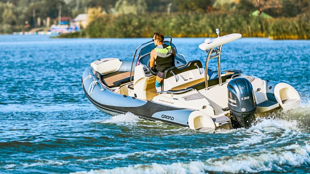 An image of the Grand G580 on the water with a male driver at the helm of the boat.