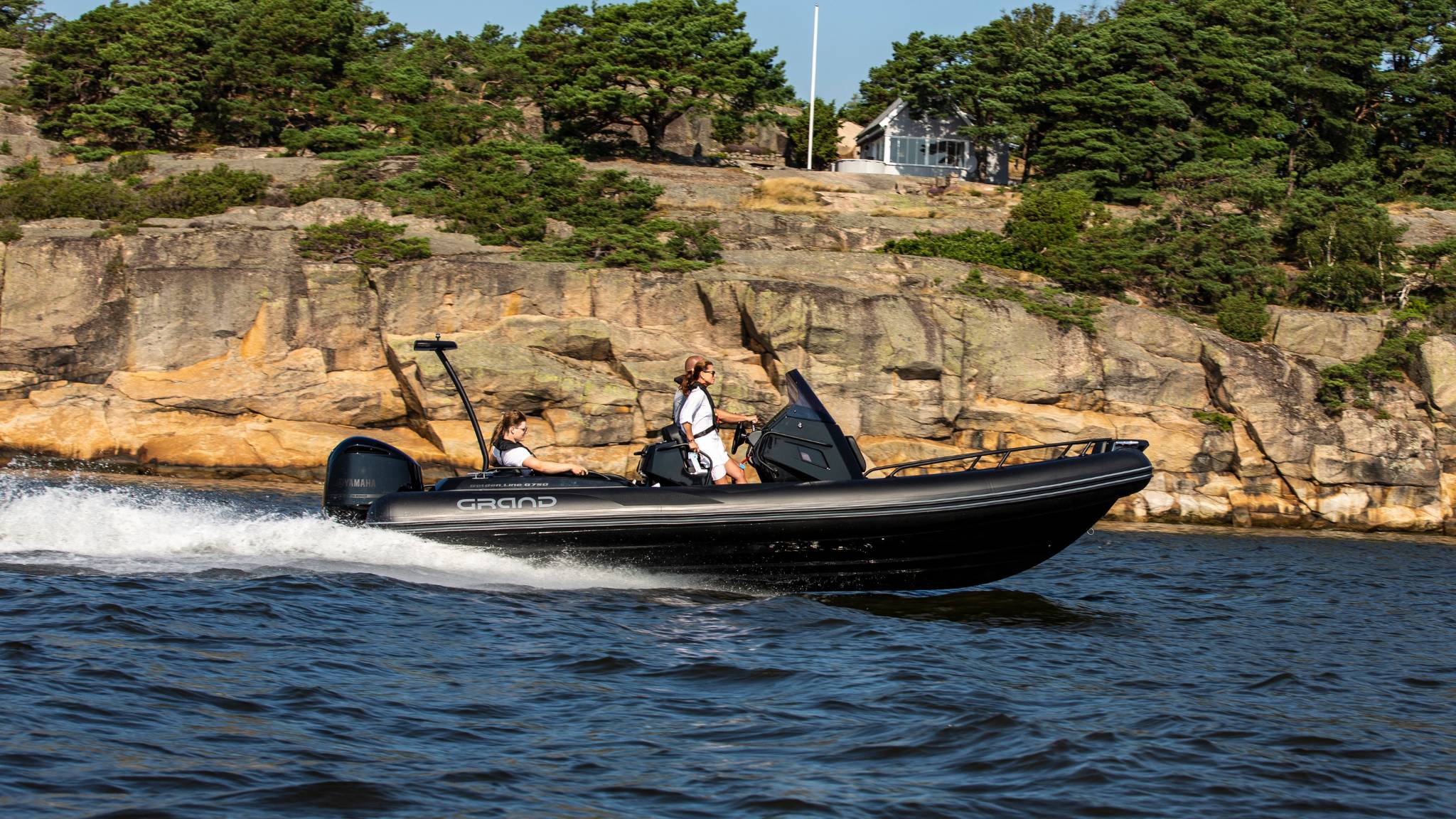 A Grand G750 rigid inflatable boat on the water with a family on board