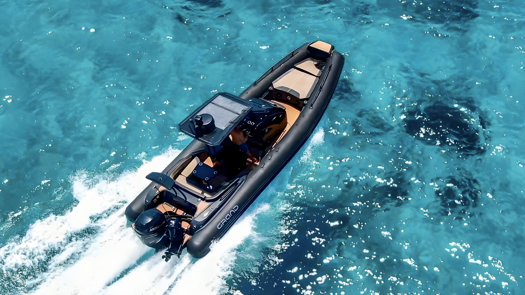 A Grand G850 rigid inflatable boat with black tubes travelling through blue water