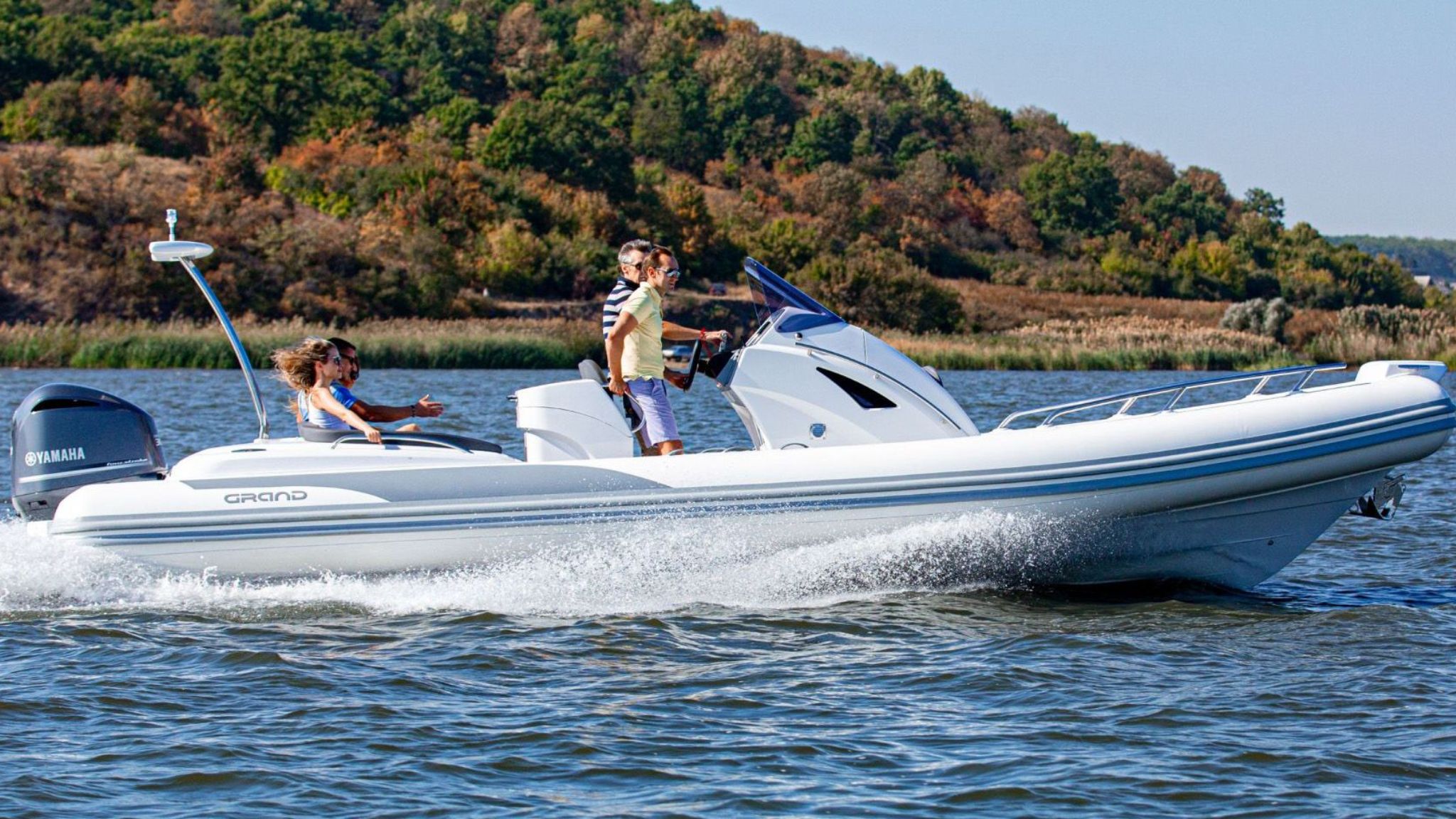 A white Grand G850 rigid inflatable boat with four passengers on board travelling on the water