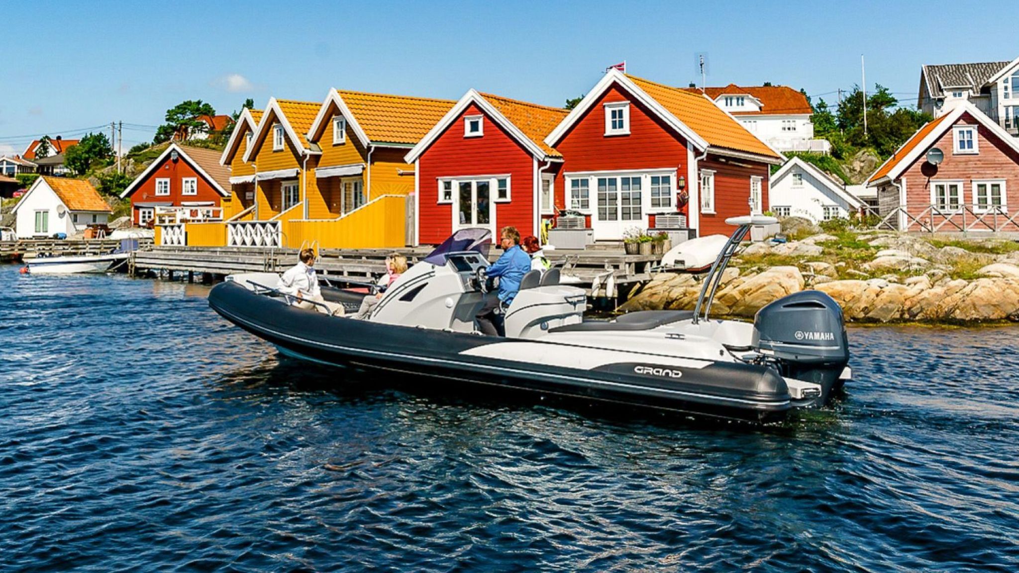 A black and white Grand G850 rigid inflatable boat travelling through Norwegian coastal waters