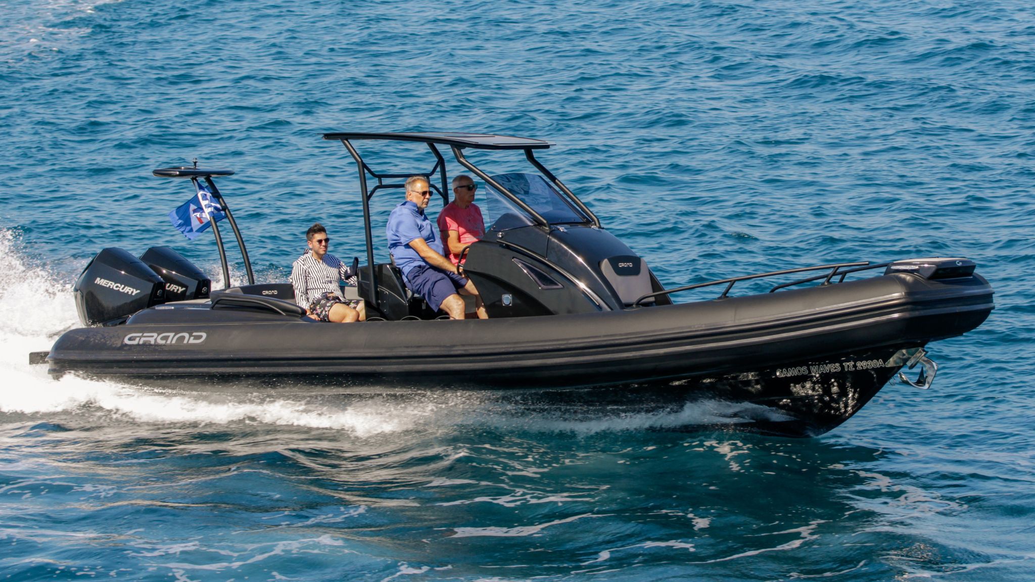 A black G850 rigid inflatable boat with a t-top travelling through the water