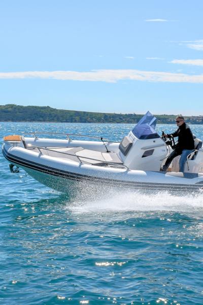 A Grand G750 rigid inflatable boat on the water with a man driving