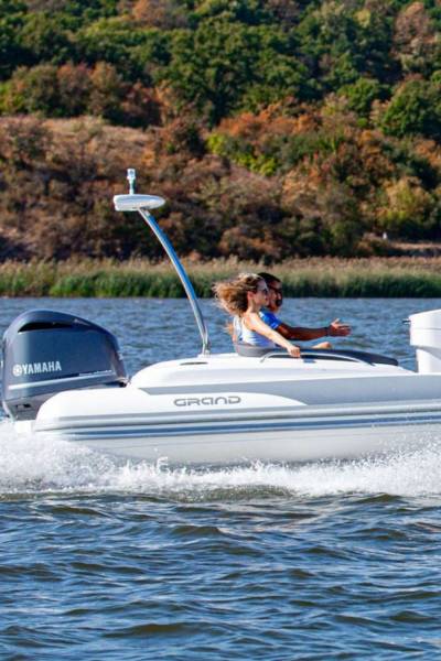 A white Grand G850 rigid inflatable boat with four passengers on board travelling on the water