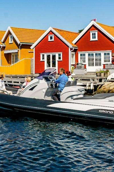 A black and white Grand G850 rigid inflatable boat travelling through Norwegian coastal waters