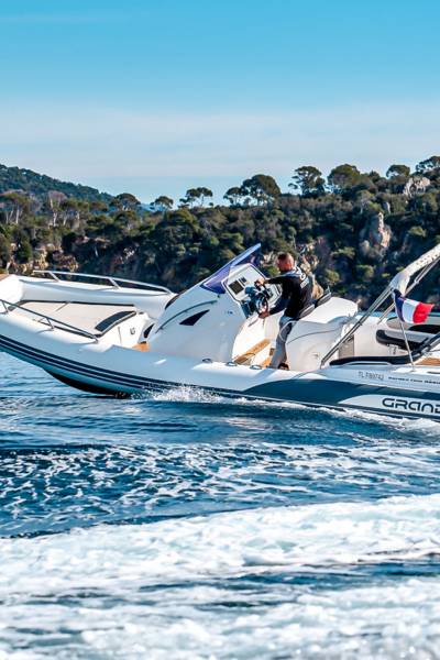 A white Grand G850 rigid inflatable boat with twin engines travelling through the water