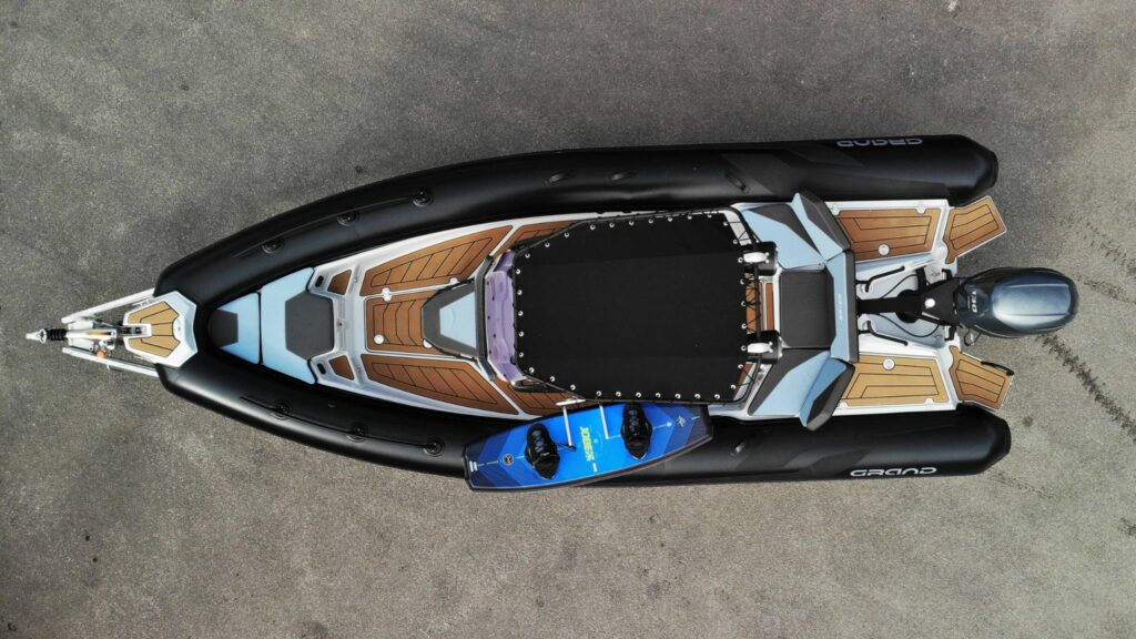 A Grand D600 boat from above, with black t-top and a wakeboard racked up onto the boat