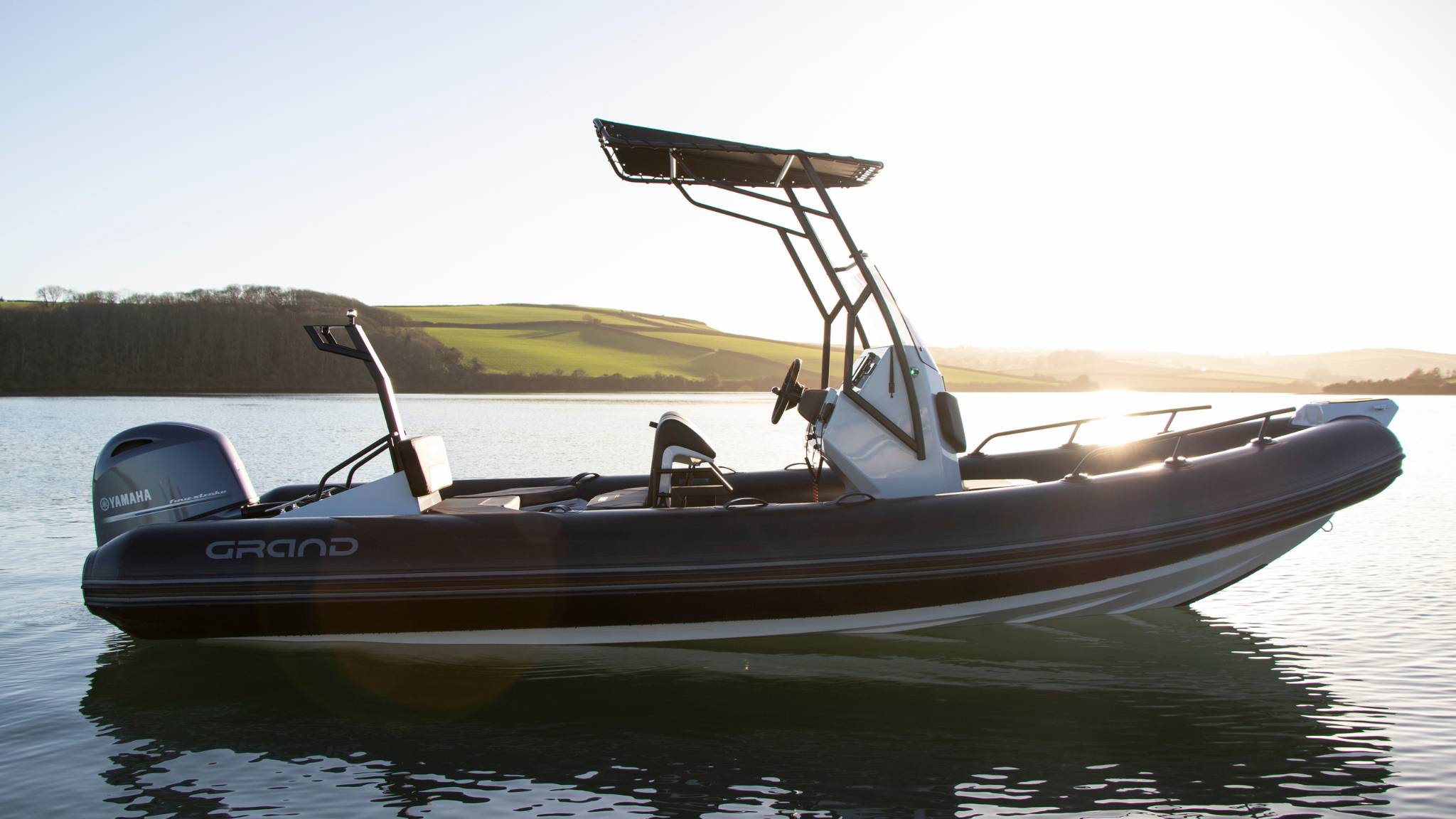 A Grand D600 inflatable boat sat on the water in the sunset