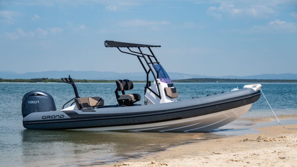 A Grand D600 6 metre rigid inflatable boat beached on the sand