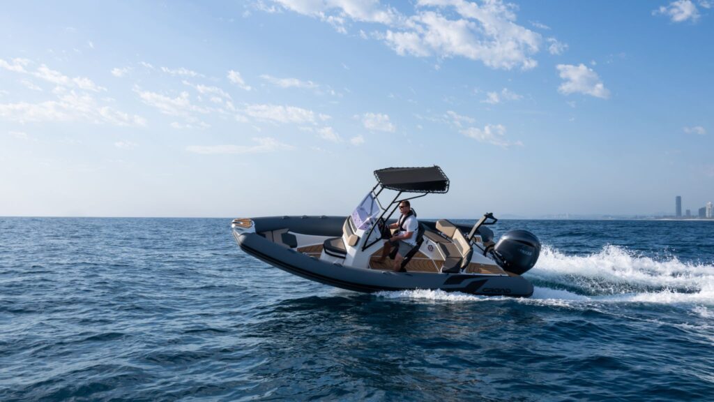 A 6 metre rigid inflatable boat turning on the water with a passenger on board