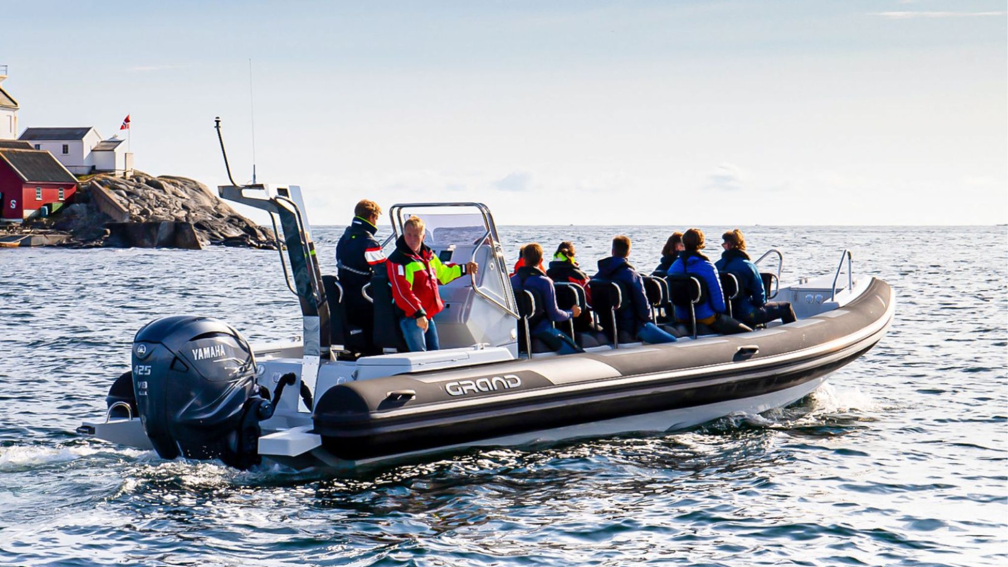 Grand D950 commercial RIB boat heading out offshore on the water with numerous passengers on board