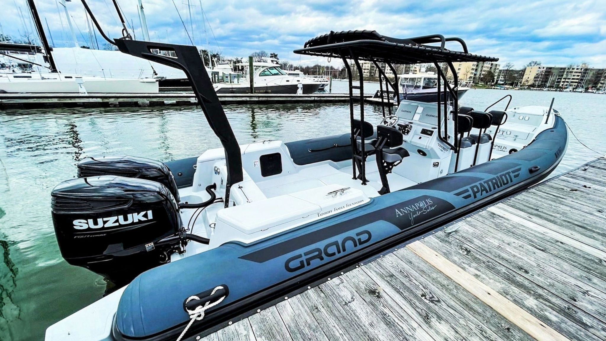 Grand D950 commercial rigid inflatable boat moored against a wooden pontoon