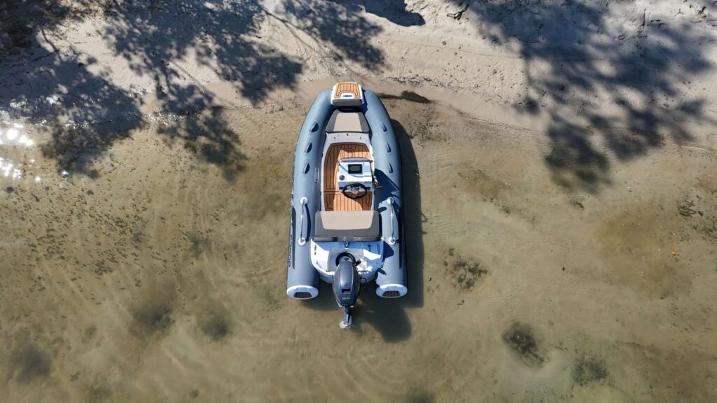 The Grand G340 tender boat beached on the sand in clear water