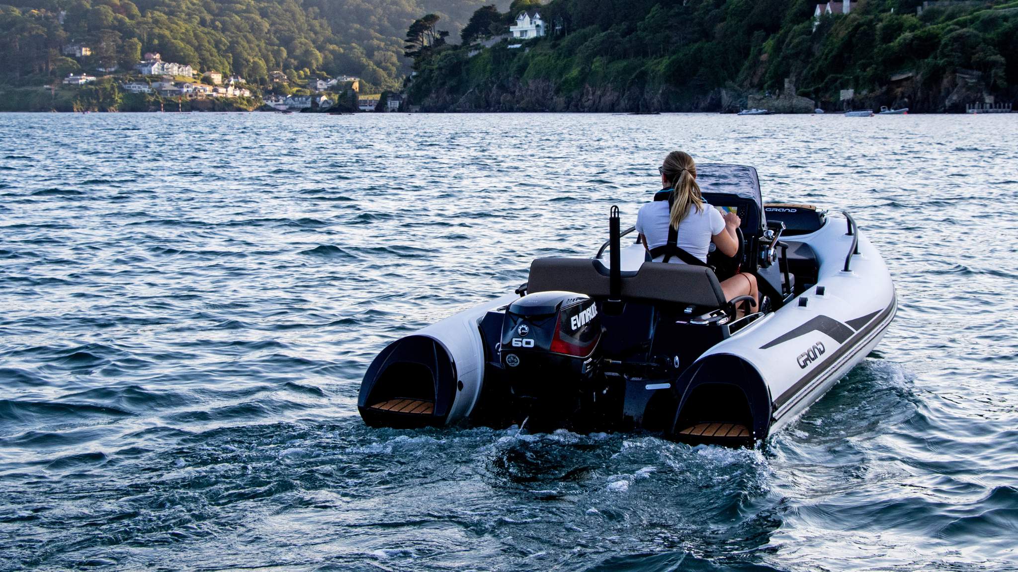 A female driving the Grand G420 boat in a harbour
