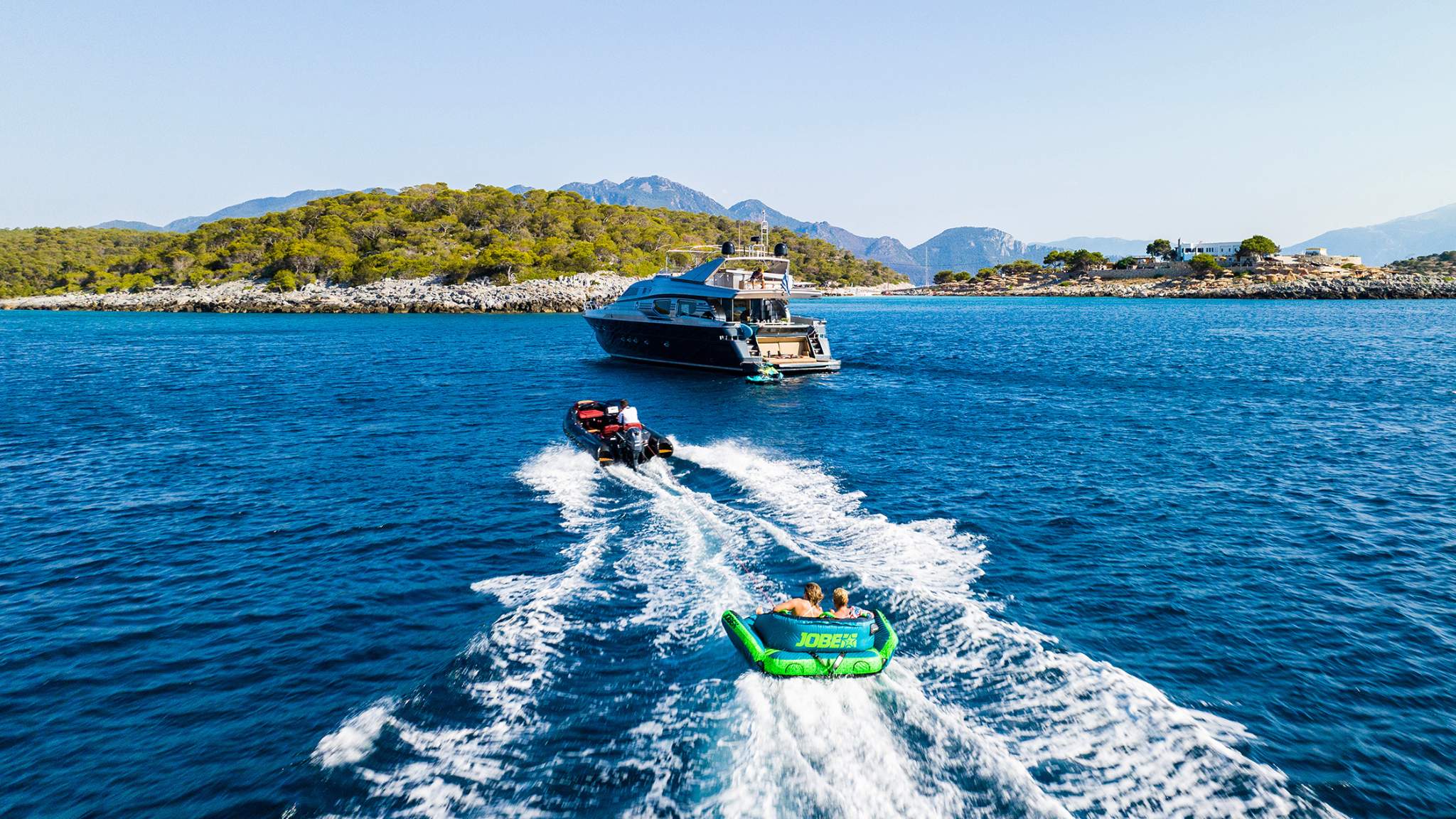 A render image of the Grand G420 tender boat towing an inflatable toy with passengers on board