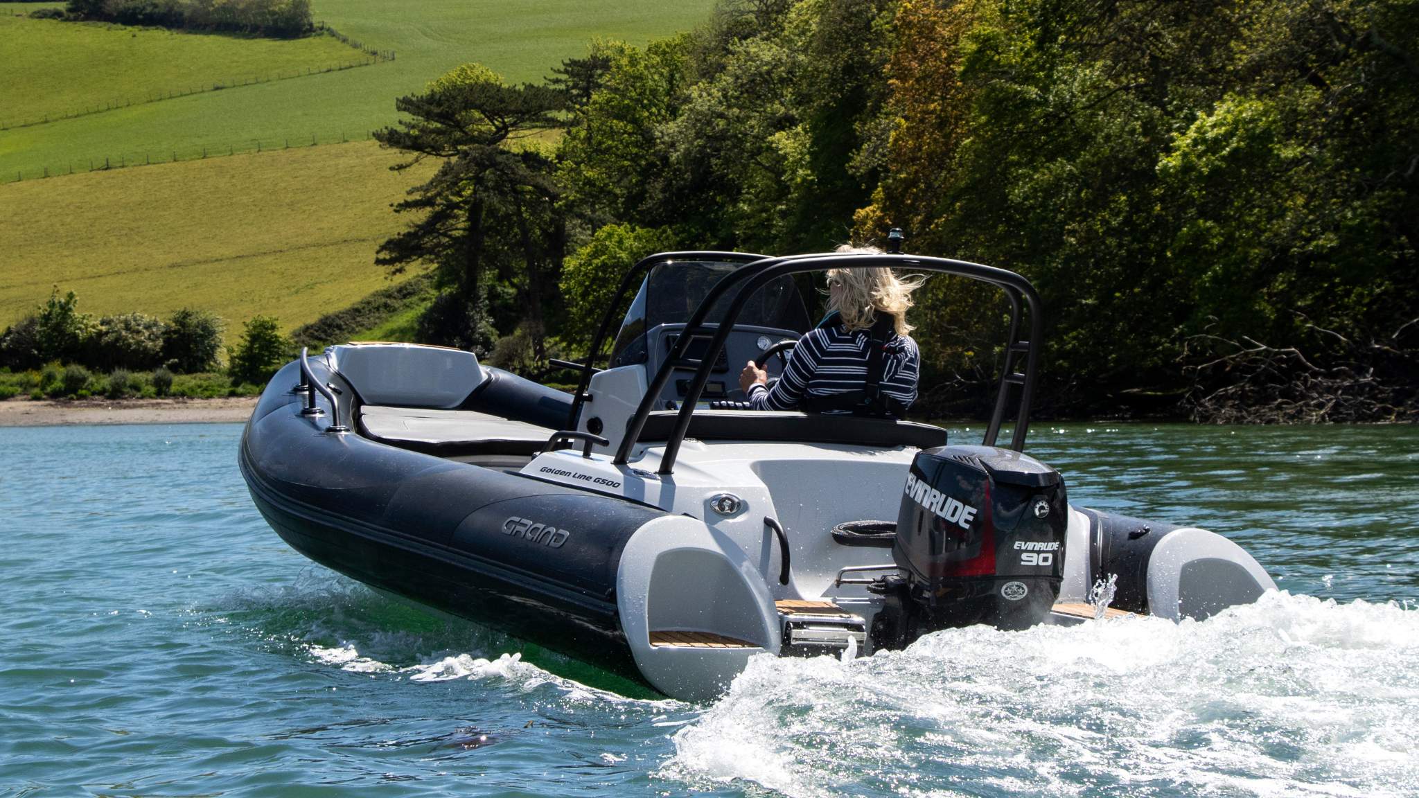 A Grand G500 boat on the water being driven by a woman
