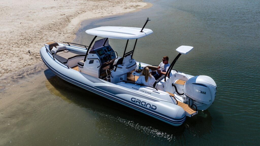 Two passengers sat on the Grand G750 beached on the sand