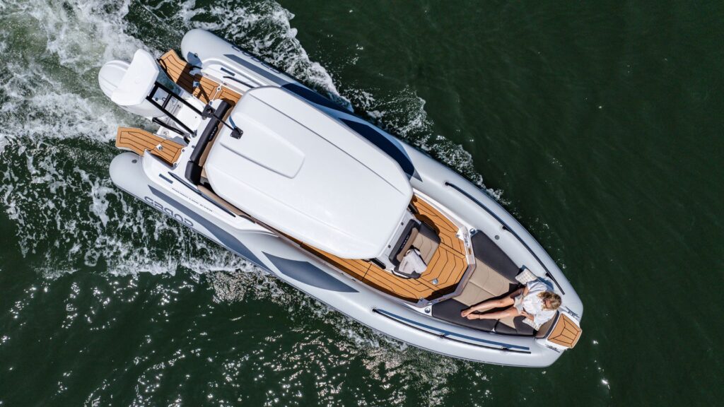 Grand G750 rib boat travelling on the water with a passenger relaxing on the bow