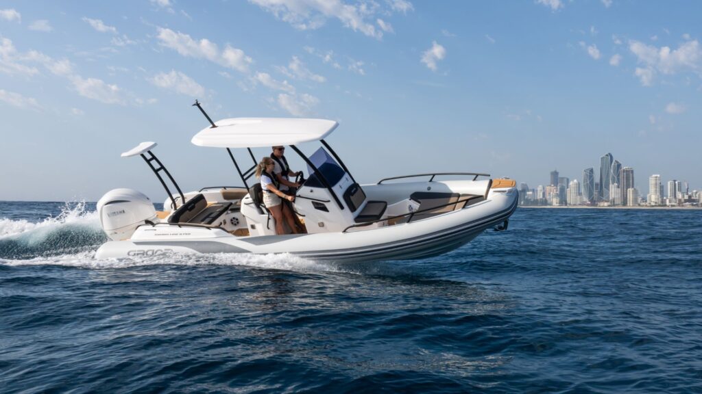 Grand G750 RIB boat on the water with a cityscape in the background, two passengers on board