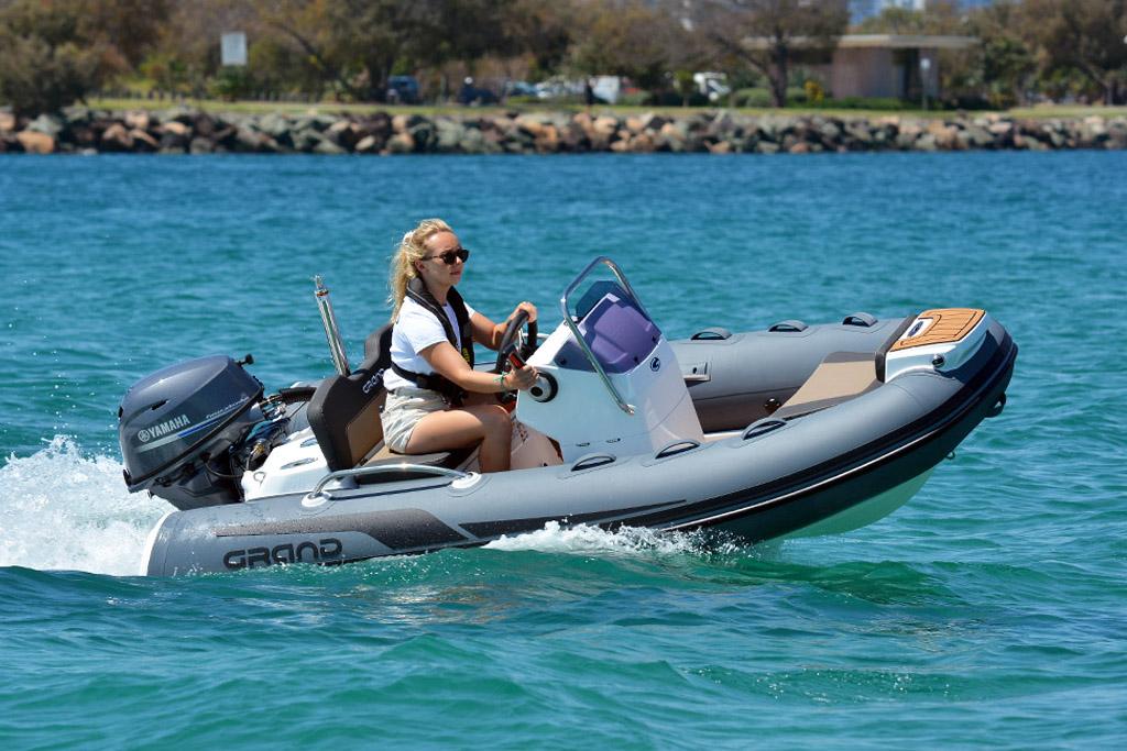 Grand G340 tender boat on the water with a woman driving it
