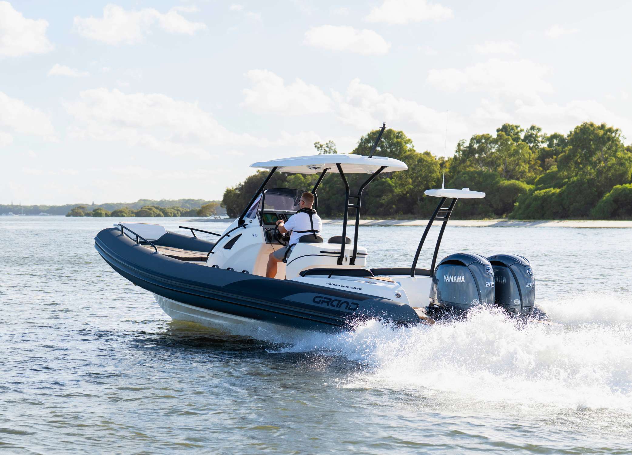 Man driving a Grand G850 rigid inflatable boat with twin engines