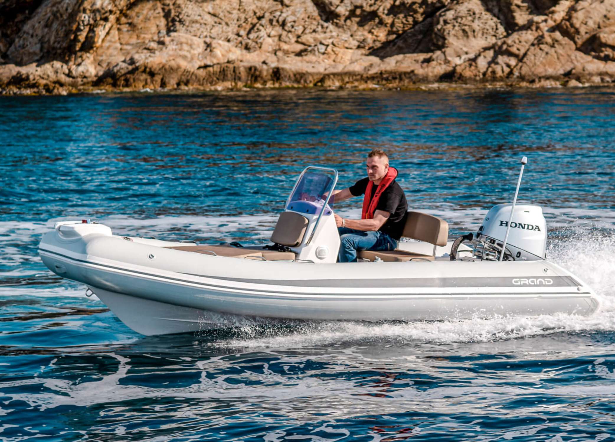Man driving a 4.7 metre tender boat the Grand S470