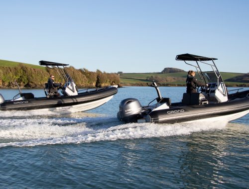 Two Grand D600s with black tubes on the water, serving as Diving Boats