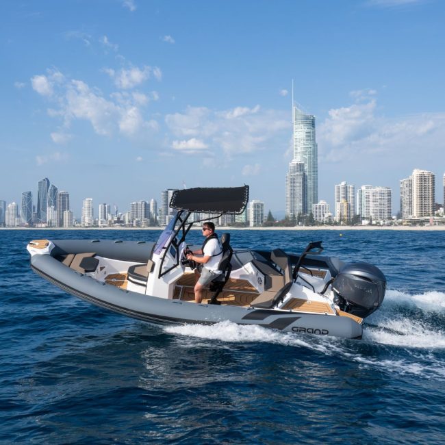 A 6 metre rigid inflatable boat travelling past the Gold Coast skyline on the water