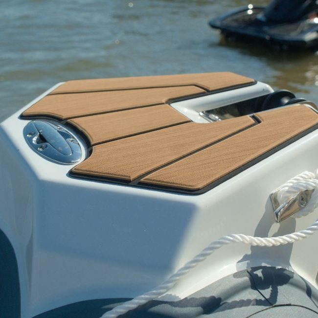 The bow step plate on the Grand D600 for sale, with SeaDek flooring and a retractive mooring cleat