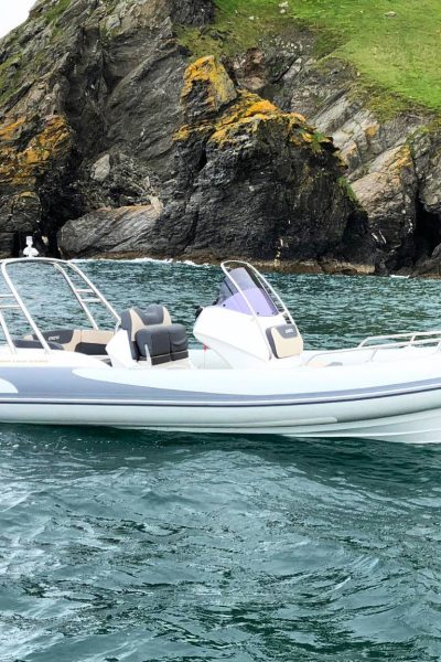 A Grand G580 boat sat on the water near a cliff