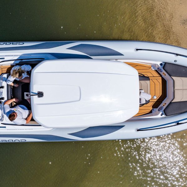 Grand G750 RIB boat beached on the sand with two passengers sat on the seating